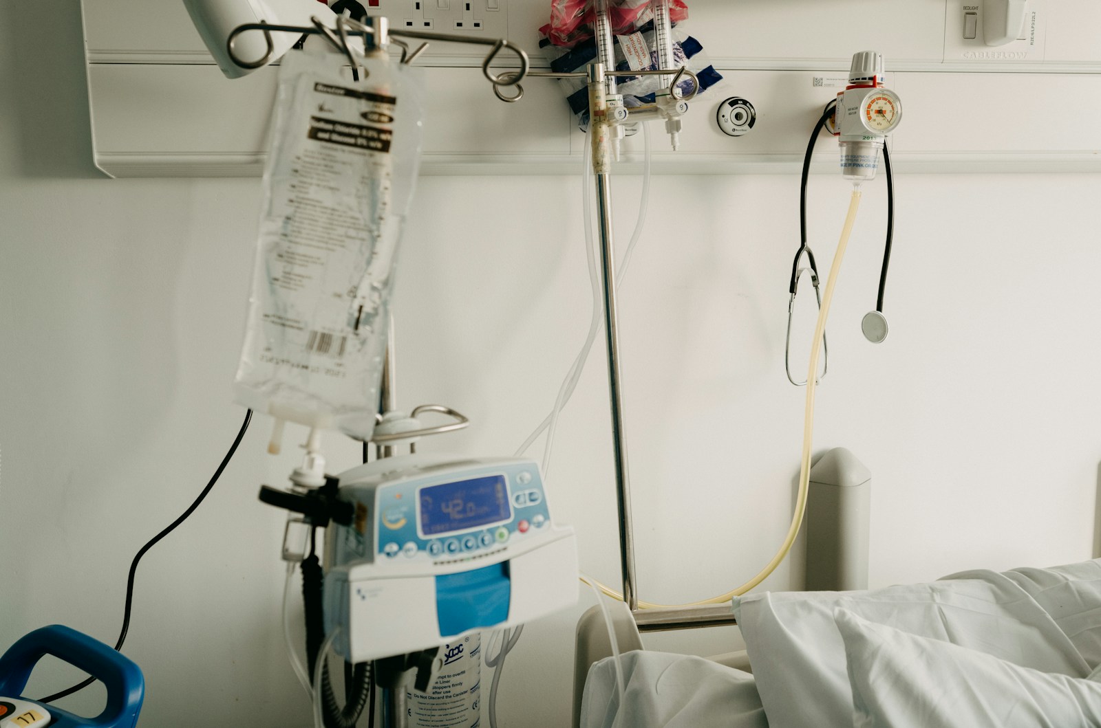 Bedside medical equipment in a home hospital room set up for in-home alcohol withdrawal monitoring.